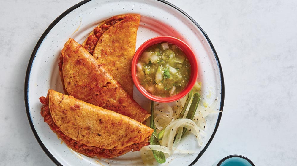 Tacos dorados. De delicioso chicharrón prensado bañados con salsa de frijol.